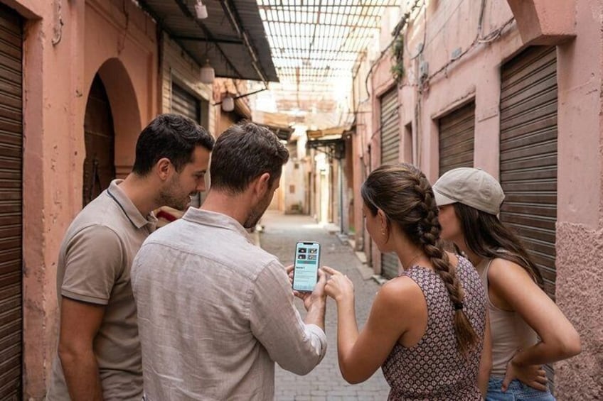 A narrow alley with closed shops and a person using a smartphone. 2