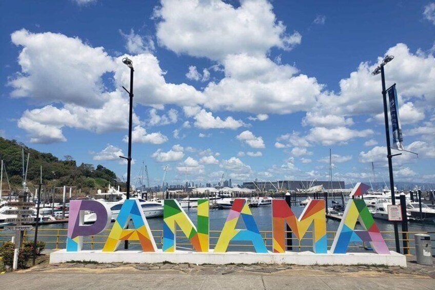 Een jachthaven met kleurrijke letters die 'PANAMA' spellen en boten op de achtergrond. 1
