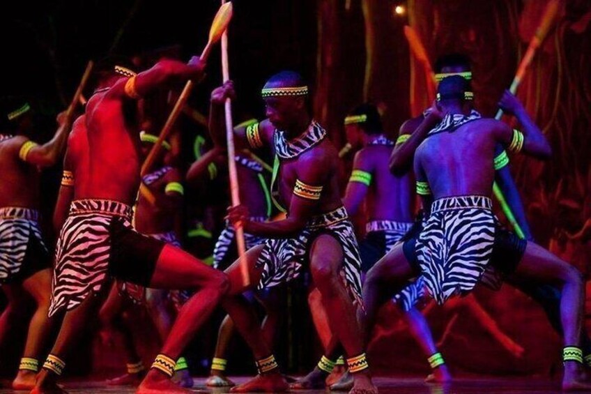 A group of dancers in traditional attire performing on stage. 2