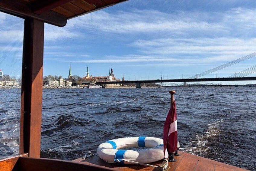 A boat on water with a cityscape and a bridge in the background. 3