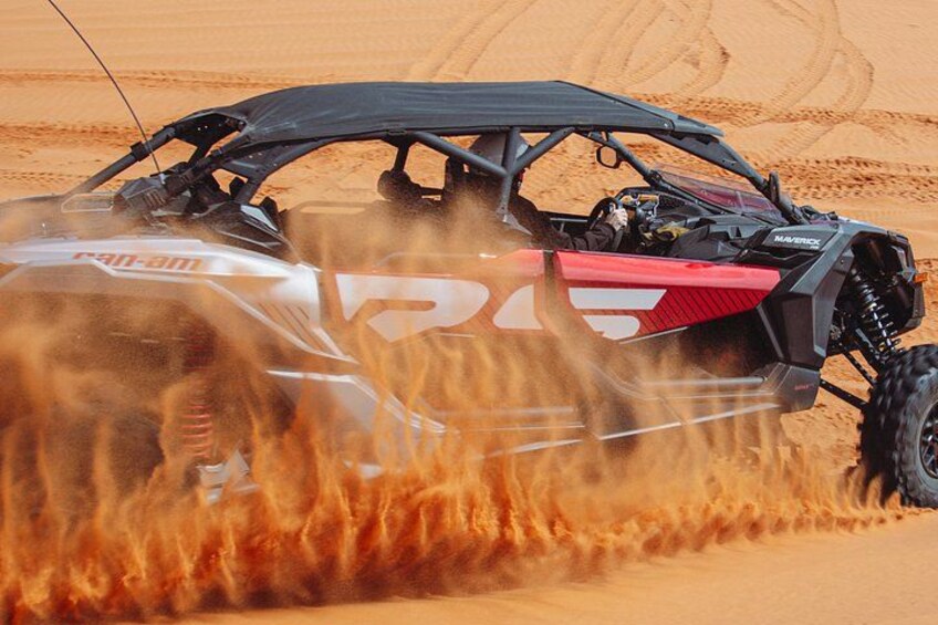 A vehicle driving through a sandy terrain with dust being kicked up. 5