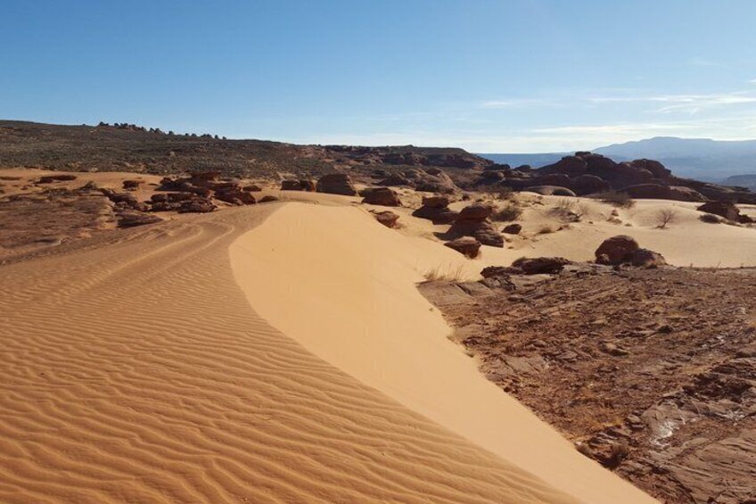 Woestijnlandschap met zandduinen en rotsachtig terrein. 2