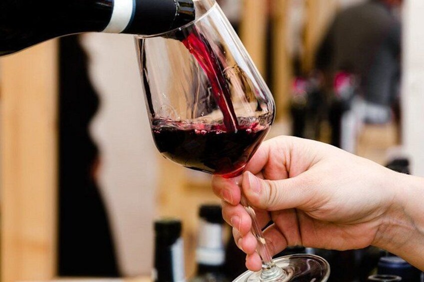 Une personne qui verse du vin rouge dans un verre. 2