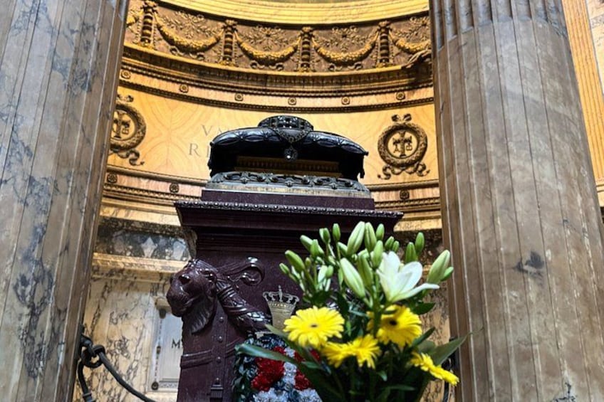 A marble column with a floral arrangement and a decorative urn. 3