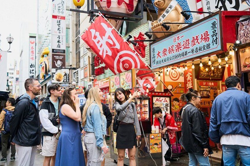 Une rue animée, bordée de boutiques, de passants et de panneaux en langue étrangère. 3