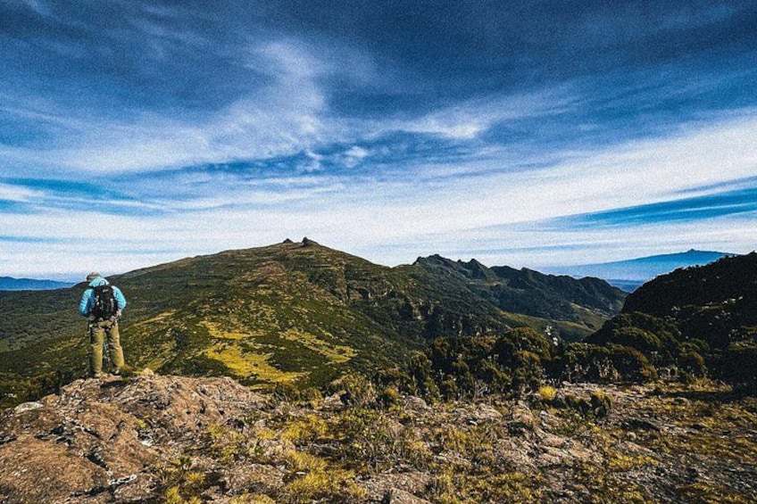 Un excursionista en la cresta de una montaña bajo un cielo despejado. 1