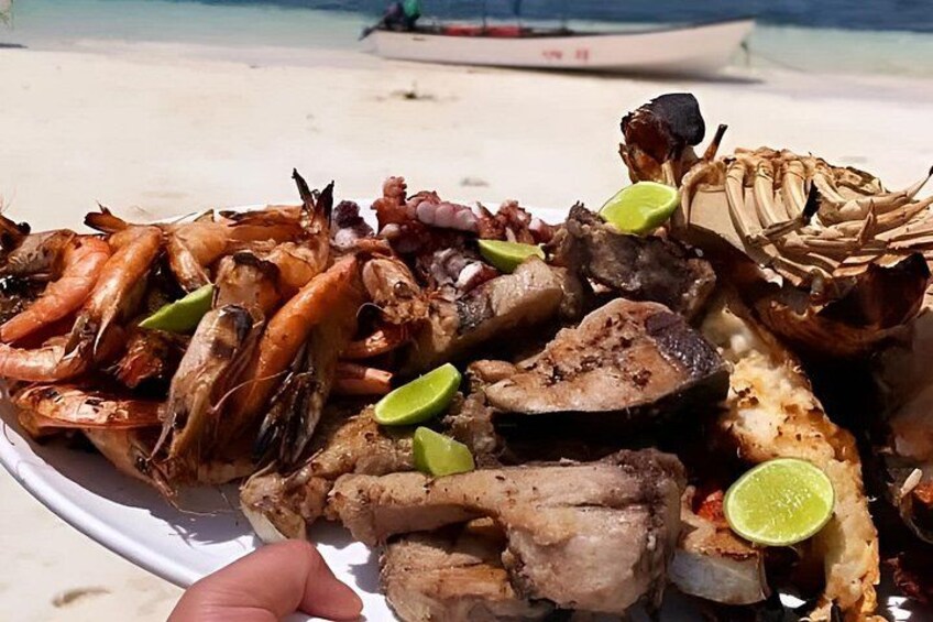 Ett urval av skaldjur, inklusive räkor, bläckfisk och hummer, serverat på en tallrik. 3