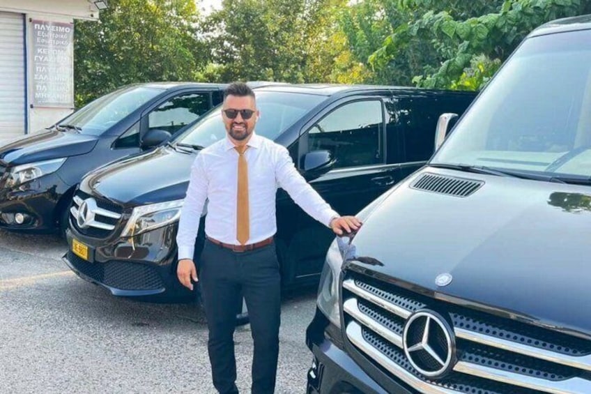 Eine Person steht neben einem schwarzen Mercedes-Benz SUV auf einem Parkplatz. 1