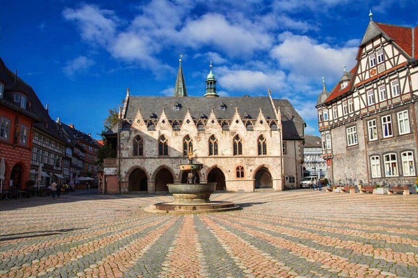 A historic building with a fountain in the center of a cobblestone square. 4