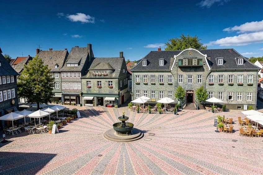 A historic building with a fountain in the center, surrounded by outdoor seating areas. 1