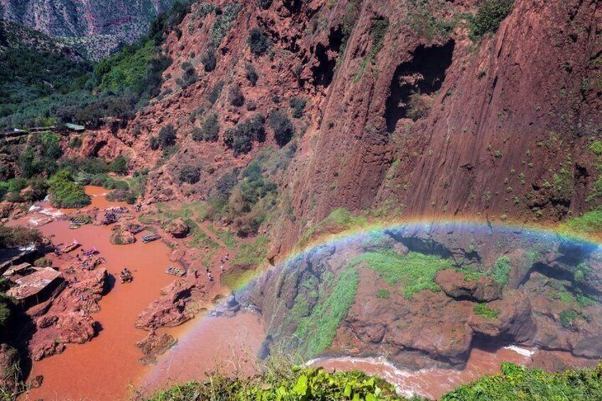 Un canyon avec une rivière rouge, un arc-en-ciel et une végétation verdoyante. 4