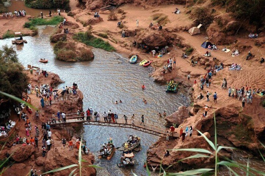 Une rivière où l’on voit des bateaux, un pont en bois et un paysage rocheux. 2