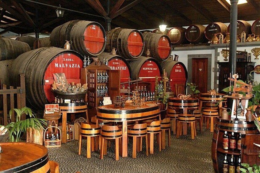 Wooden barrels, wooden stools, and a variety of bottles in a storage room. 2