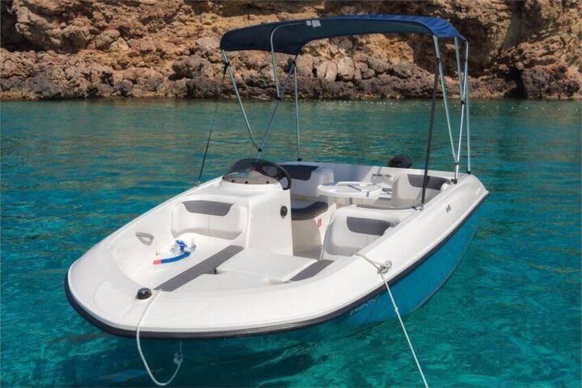 A small motorboat with a canopy, anchored near rocky cliffs. 4