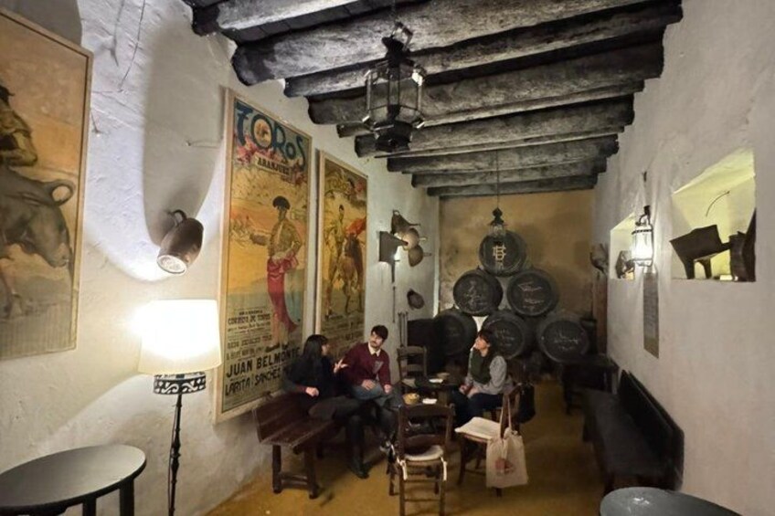 Ein rustikales Interieur mit Holzbalken, Postern und Fässern. 5