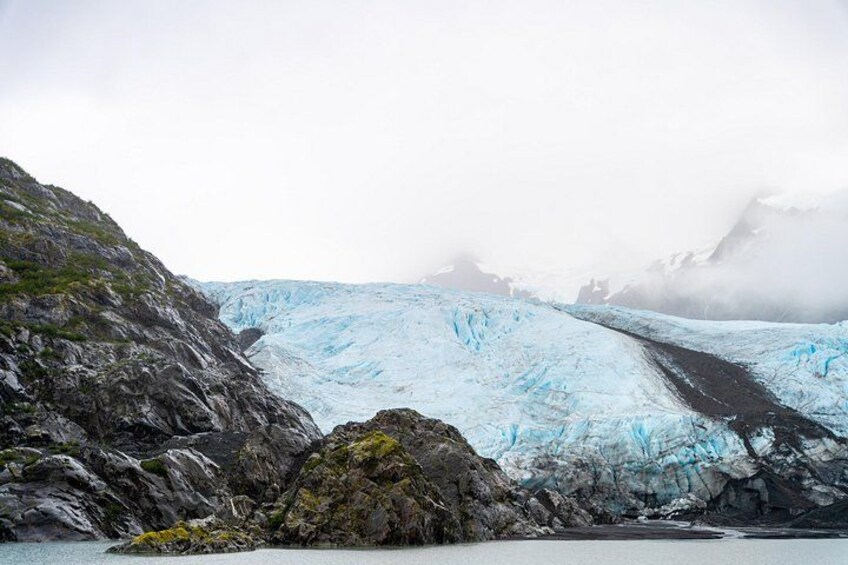 Un glacier avec un paysage rocheux au premier plan et un arrière-plan brumeux. 4