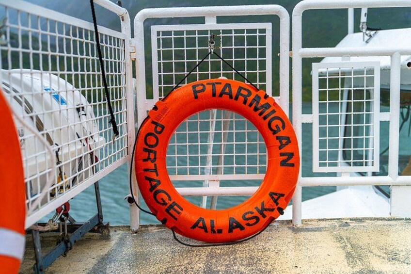 Une bouée de sauvetage sur laquelle est inscrit « Portage, Alaska », suspendue à une barrière métallique. 3