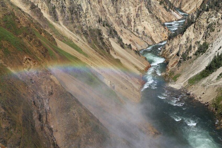 Ein Fluss schlängelt sich durch eine Schlucht, über der ein Regenbogenbogen erscheint. 4