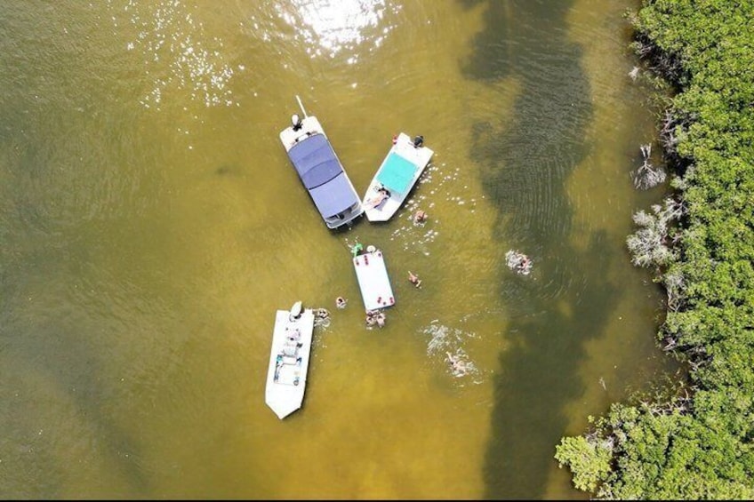 Three boats on a calm body of water with greenery on the right. 3