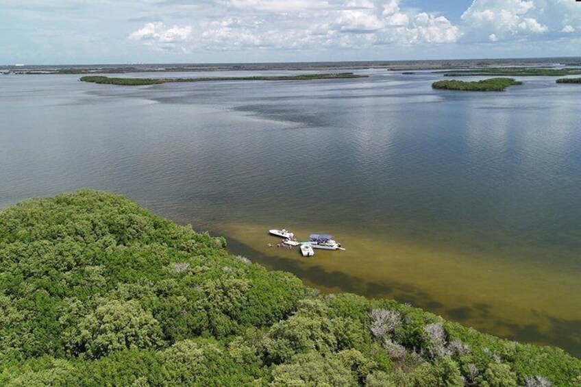 A coastal landscape with a boat docked near a forested area. 4