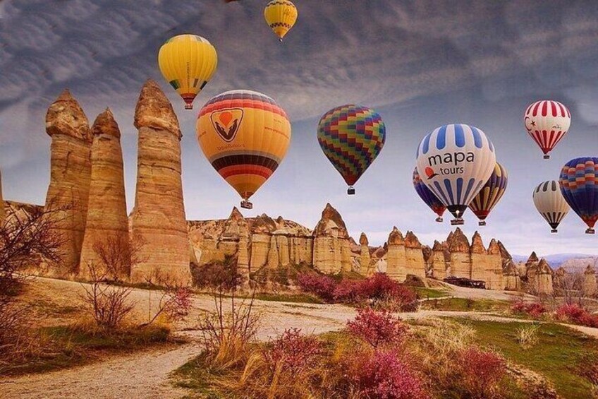 Un paisaje con formaciones rocosas y globos aerostáticos. 3