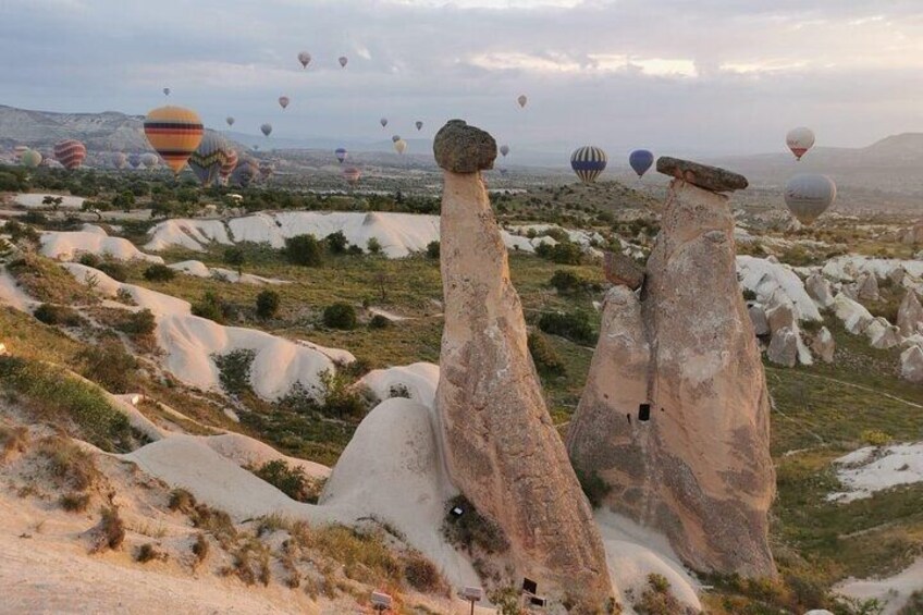 Paisaje con formaciones rocosas únicas y globos aerostáticos a lo lejos. 4