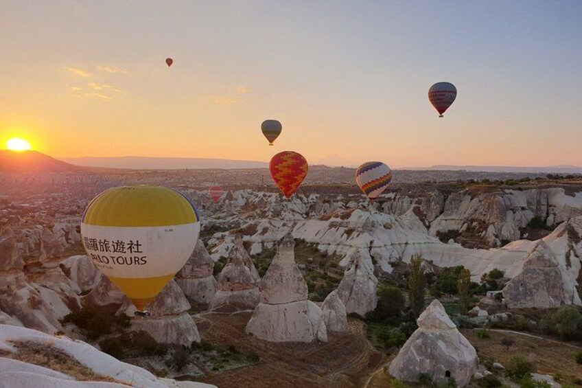 A landscape with rock formations and hot air balloons. 1