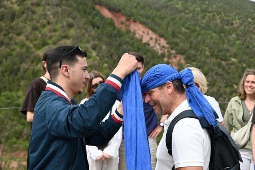 Twee personen passen een blauwe sjaal. 1