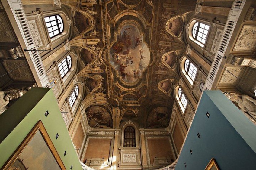 Un soffitto decorato con elaborate pitture affrescate e dettagli architettonici. 3
