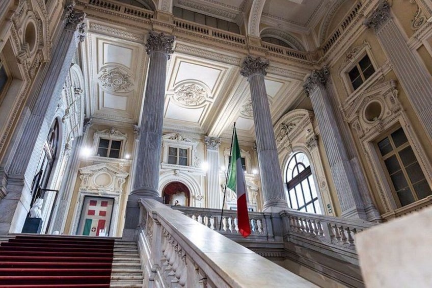 Un'imponente scalinata con colonne decorate e una bandiera. 2