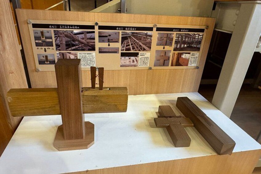 Une présentation en bois comprenant diverses structures en bois et des panneaux d’information en arrière-plan. 3