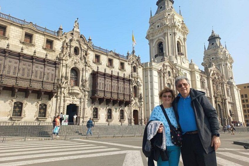 Un edificio histórico con arquitectura ornamentada, una amplia plaza abierta y un cielo despejado. 2