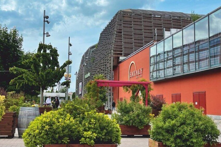 Un edificio moderno con facciata rossa e un'estensione in vetro, immerso nel verde e con un tenda rossa. 4