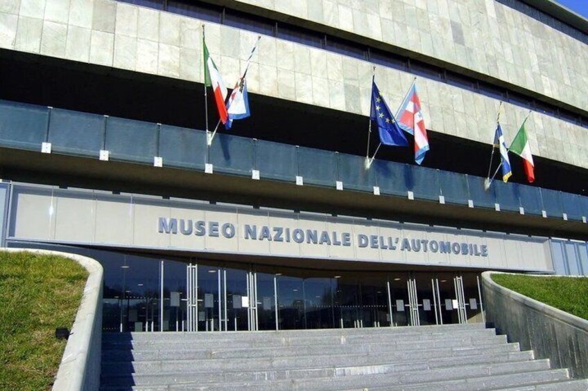 L'ingresso del Museo Nazionale dell'Automobile, con scalinate, bandiere e una moderna facciata. 1