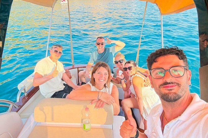 Un grupo de personas en un bote, con un fondo de agua azul cristalina. 3