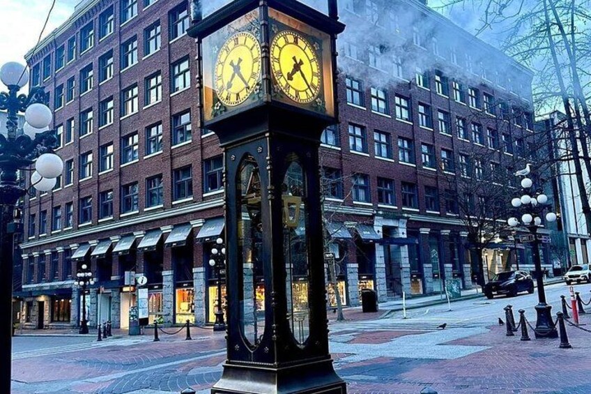 A clock tower in front of a brick building with a large clock face. 2