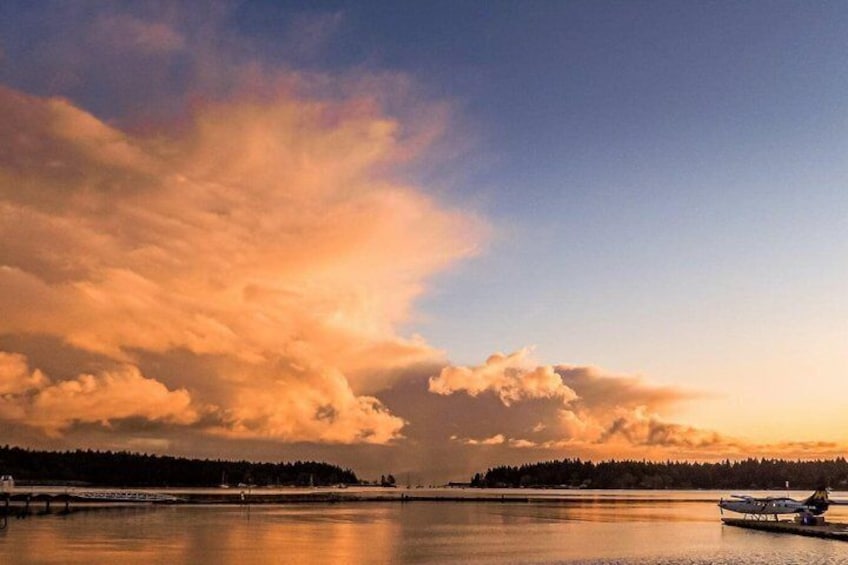 Un lago tranquilo con un bote, una orilla arbolada y un cielo al atardecer. 4