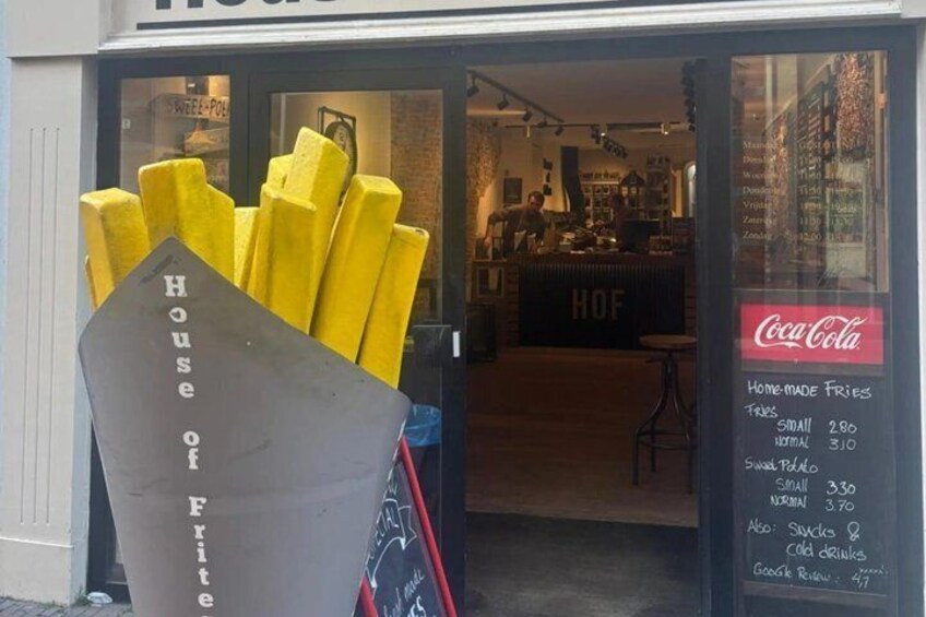 A storefront with a sign reading 'House of Fries' and a menu board listing prices for different sizes of fries. 2