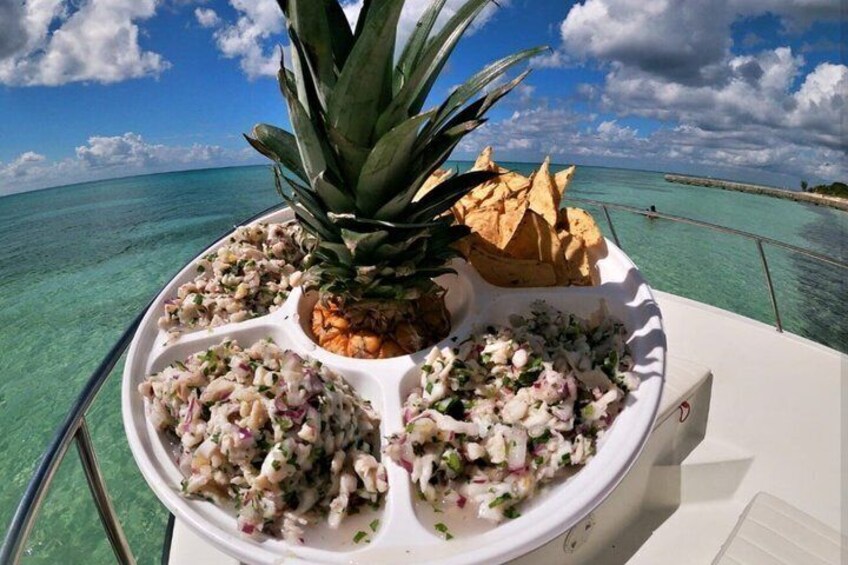 Un bote con una bandeja de comida que incluye piña, ensalada y papas fritas. 4