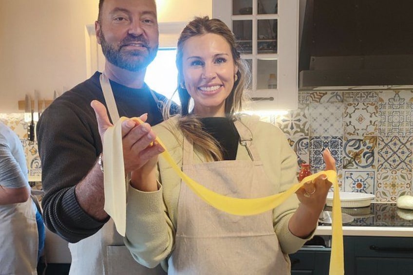Deux personnes tenant des rubans jaunes dans une cuisine dont le sol est recouvert de carreaux décoratifs. 4
