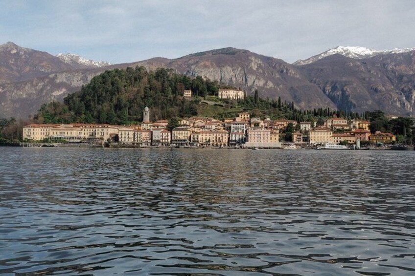 Un borgo sul lago con edifici, una chiesa e montagne sullo sfondo. 2