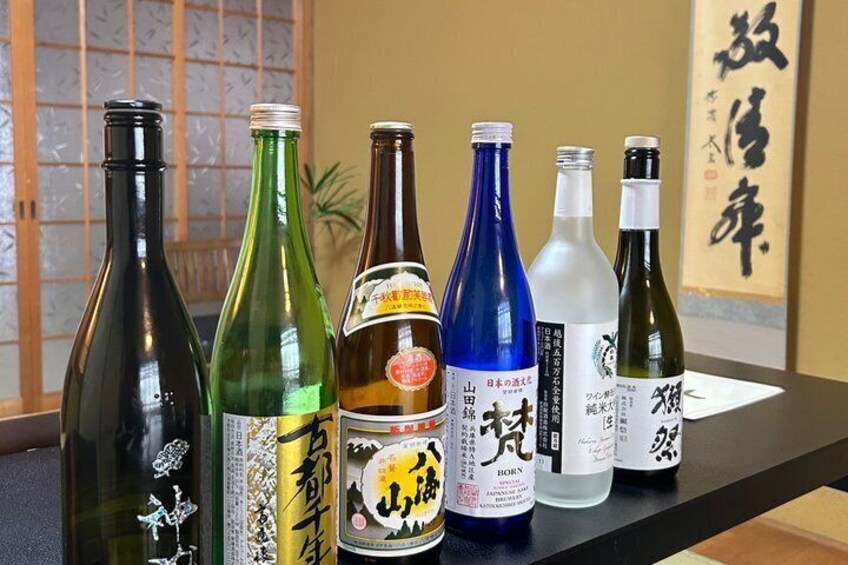 Flere flasker japansk sake står på et bord. 2
