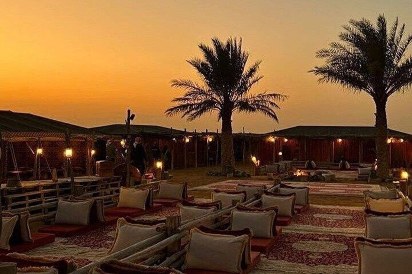 A desert resort at sunset with outdoor seating and palm trees. 5