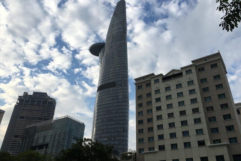 Un paisaje urbano con un rascacielos alto y cilíndrico, un edificio en construcción y un edificio residencial de varios pisos. 4