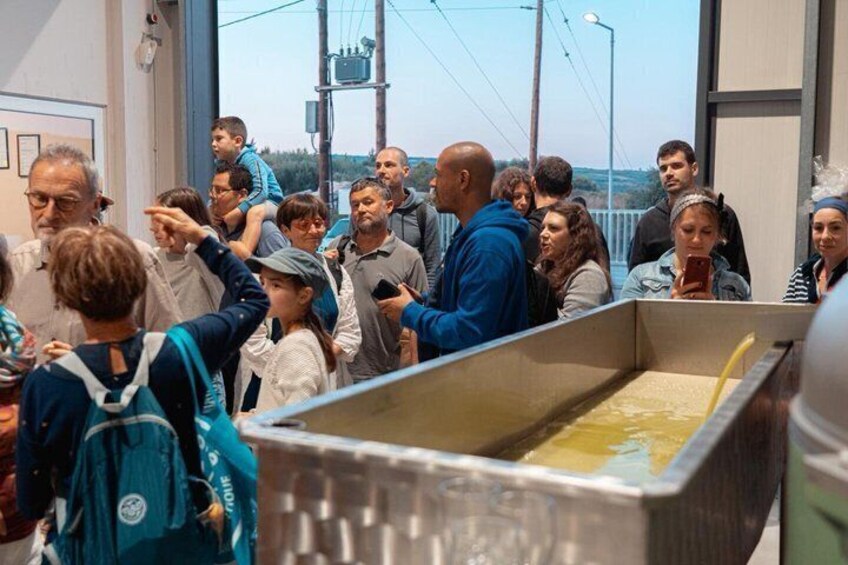 A group of people observing a large industrial tank outdoors. 3