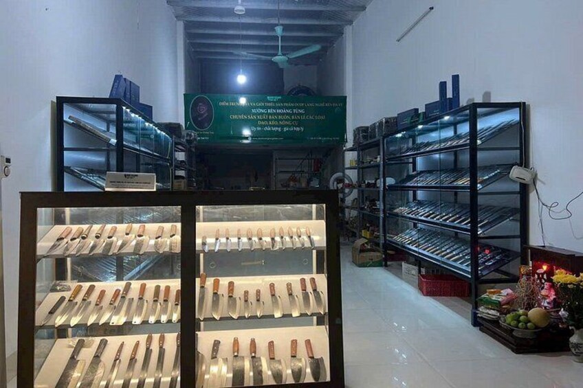 Interior de una tienda con estanterías llenas de cuchillos y una vitrina de exhibición. 3