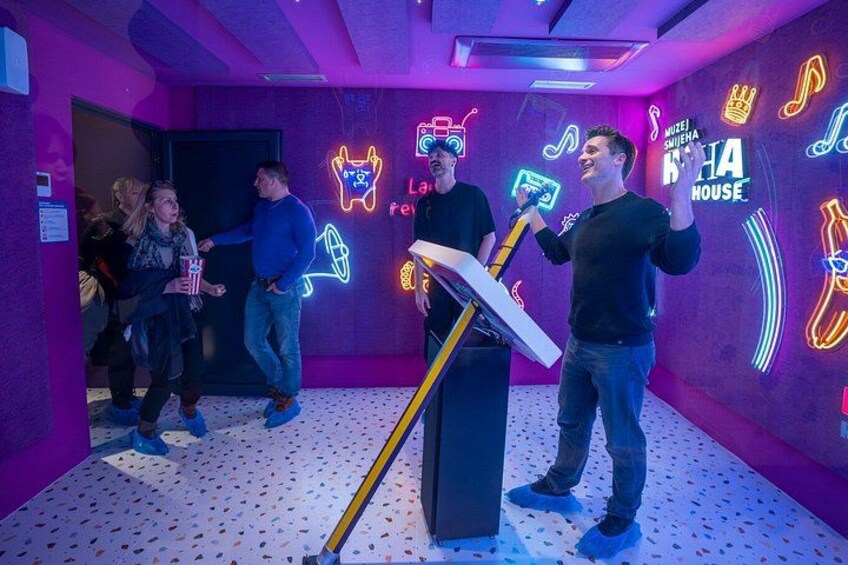 Une pièce décorée d’enseignes au néon et équipée d’un pied de microphone. 2