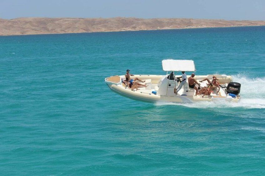 Una barca su un mare color turchese con persone a bordo. 3