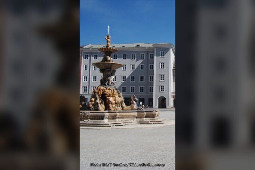 Une fontaine ornée de sculptures se trouve devant un bâtiment. 5