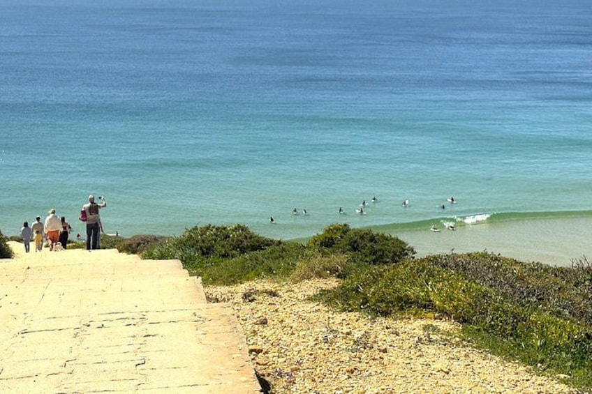 A beach with people walking and surfing. 3